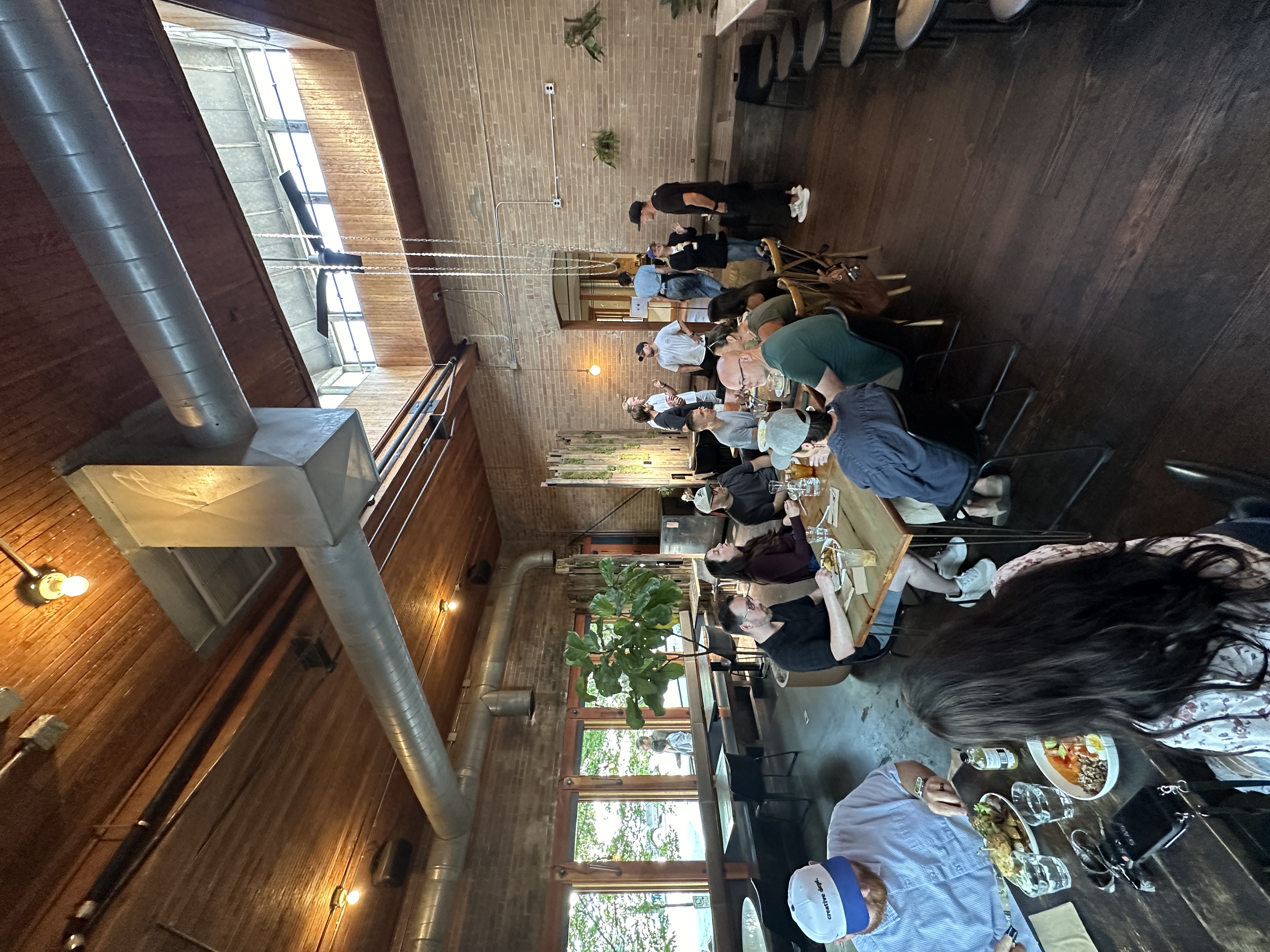 Community dining event in rustic brick-walled restaurant space