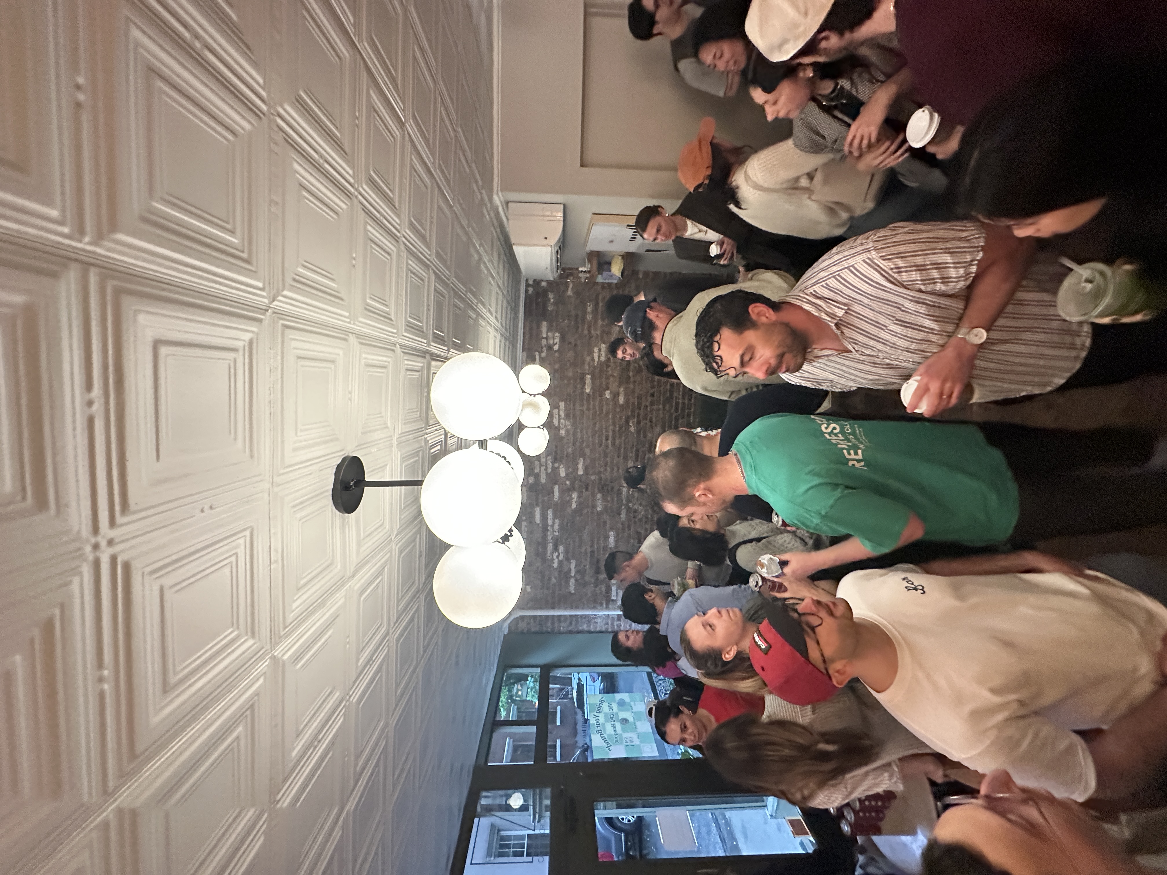 Community gathering in coffee shop with decorative tin ceiling