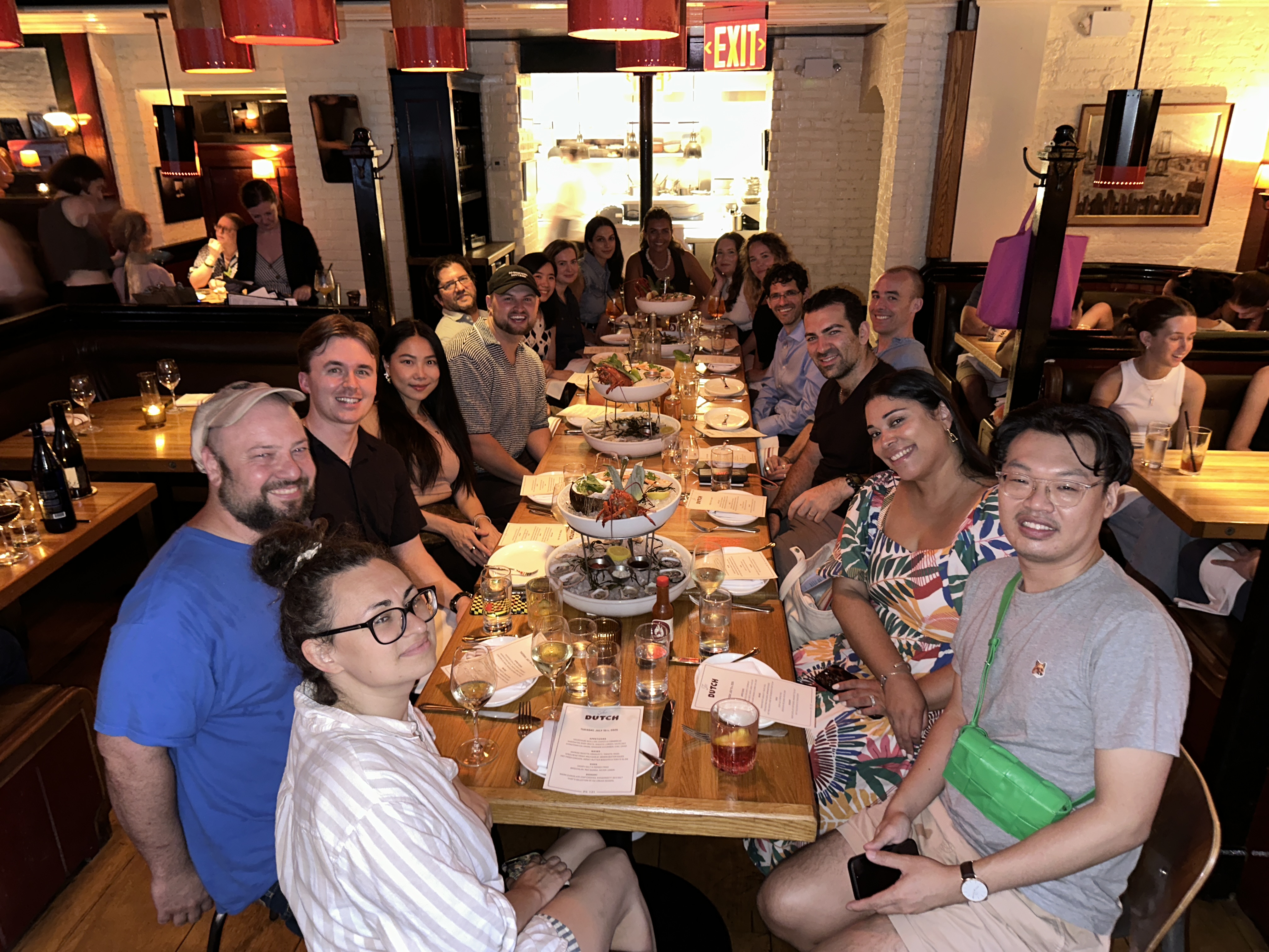 Large group dinner at restaurant with friends seated at communal table