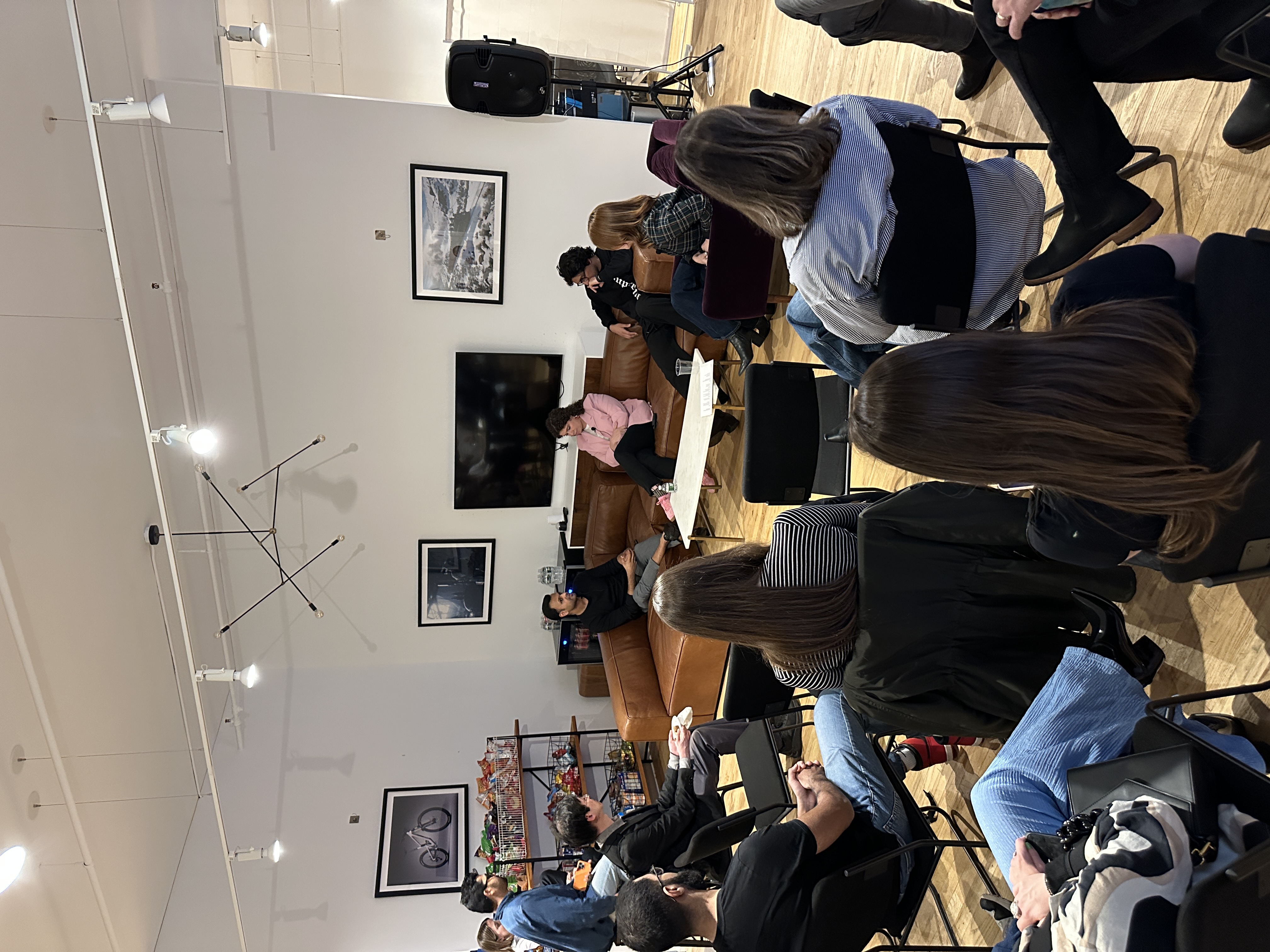 Indoor community meeting with people gathered around discussing