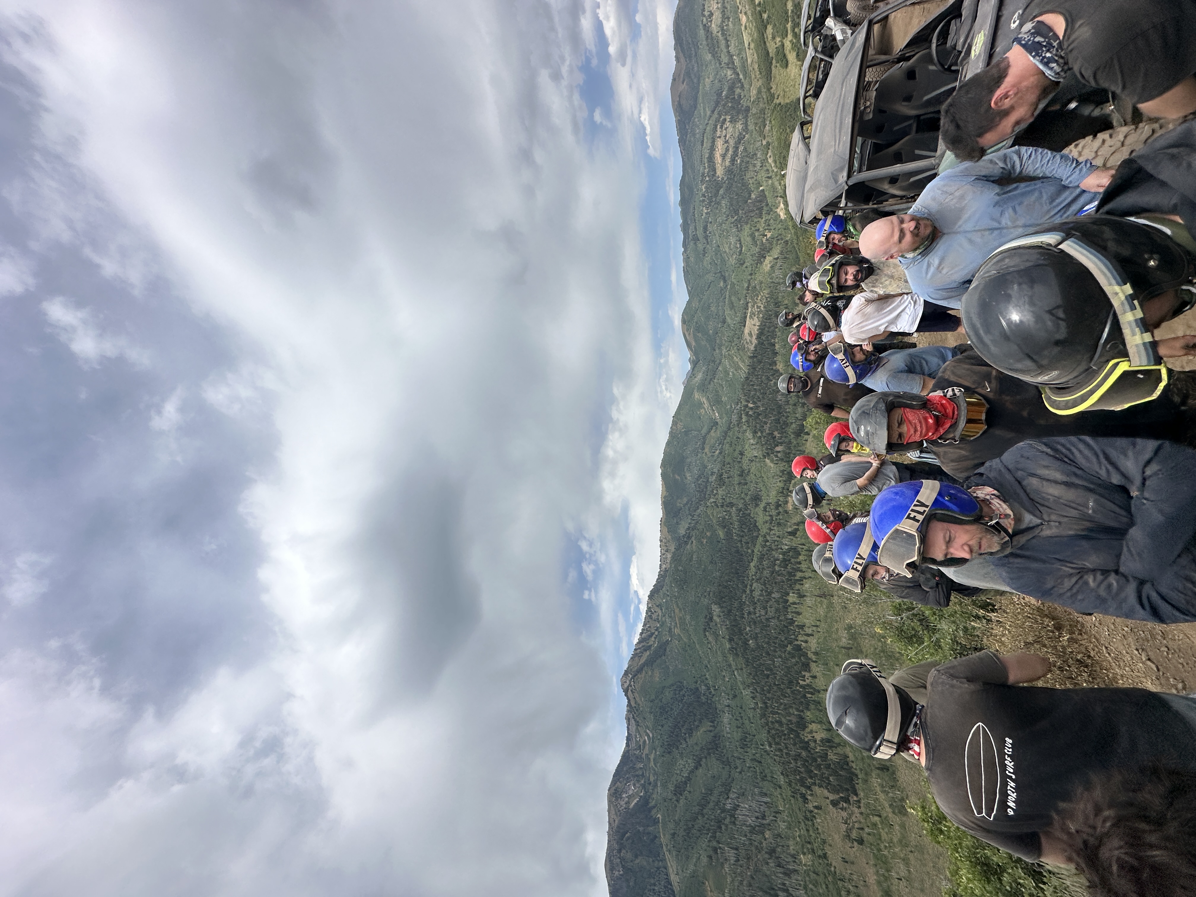 Large outdoor adventure group on mountainside with helmets and gear
