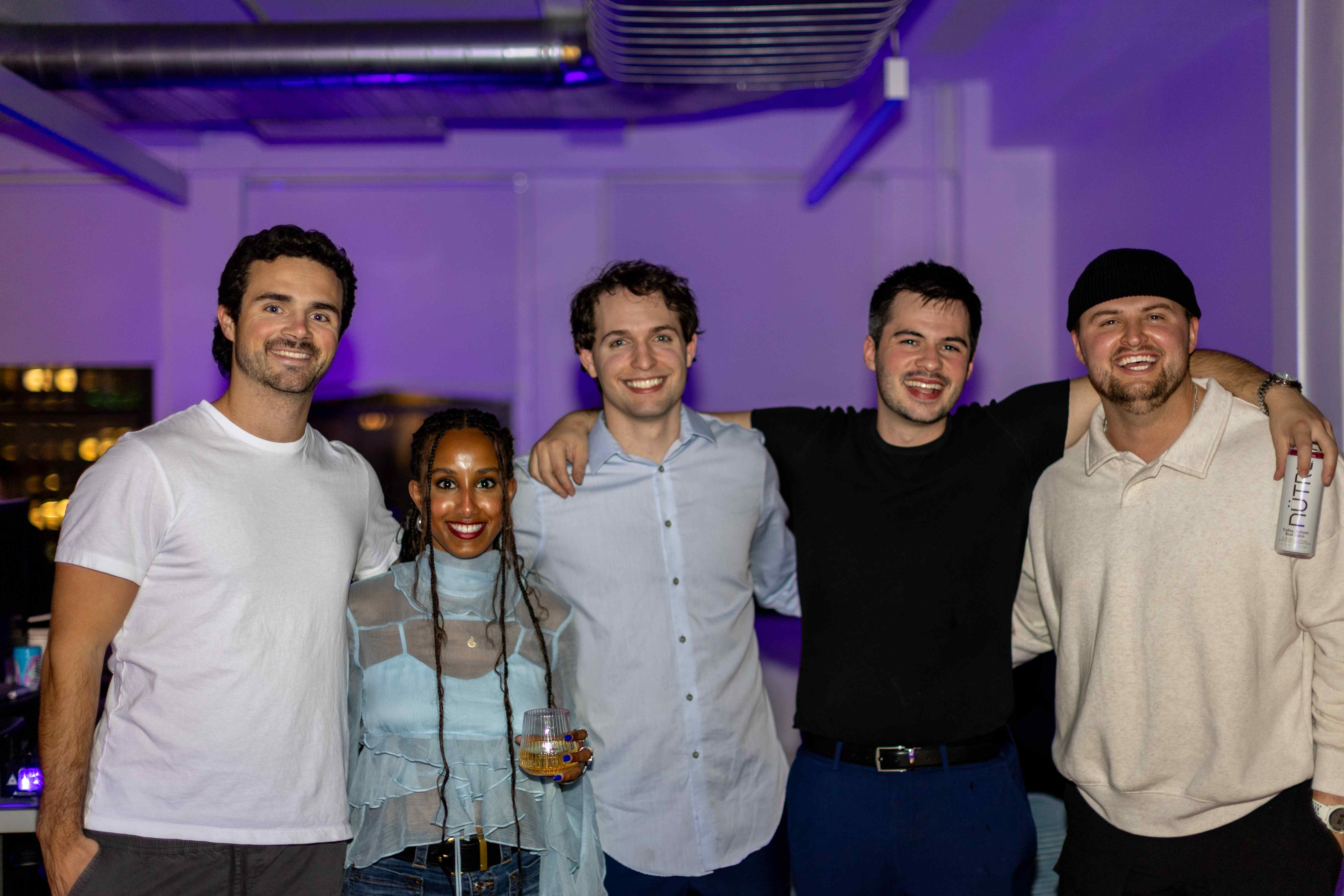 Group photo at event venue with purple ambient lighting