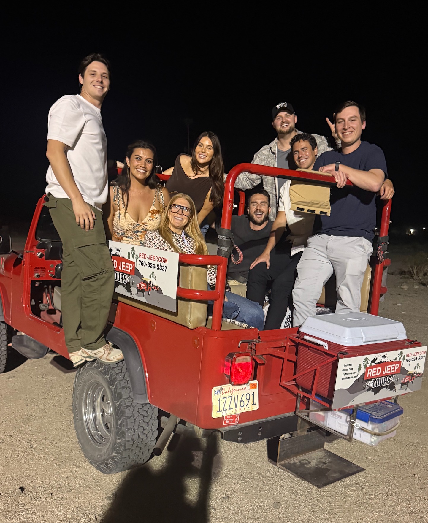 Group piled onto a Red Jeep Tours vehicle at night in the desert