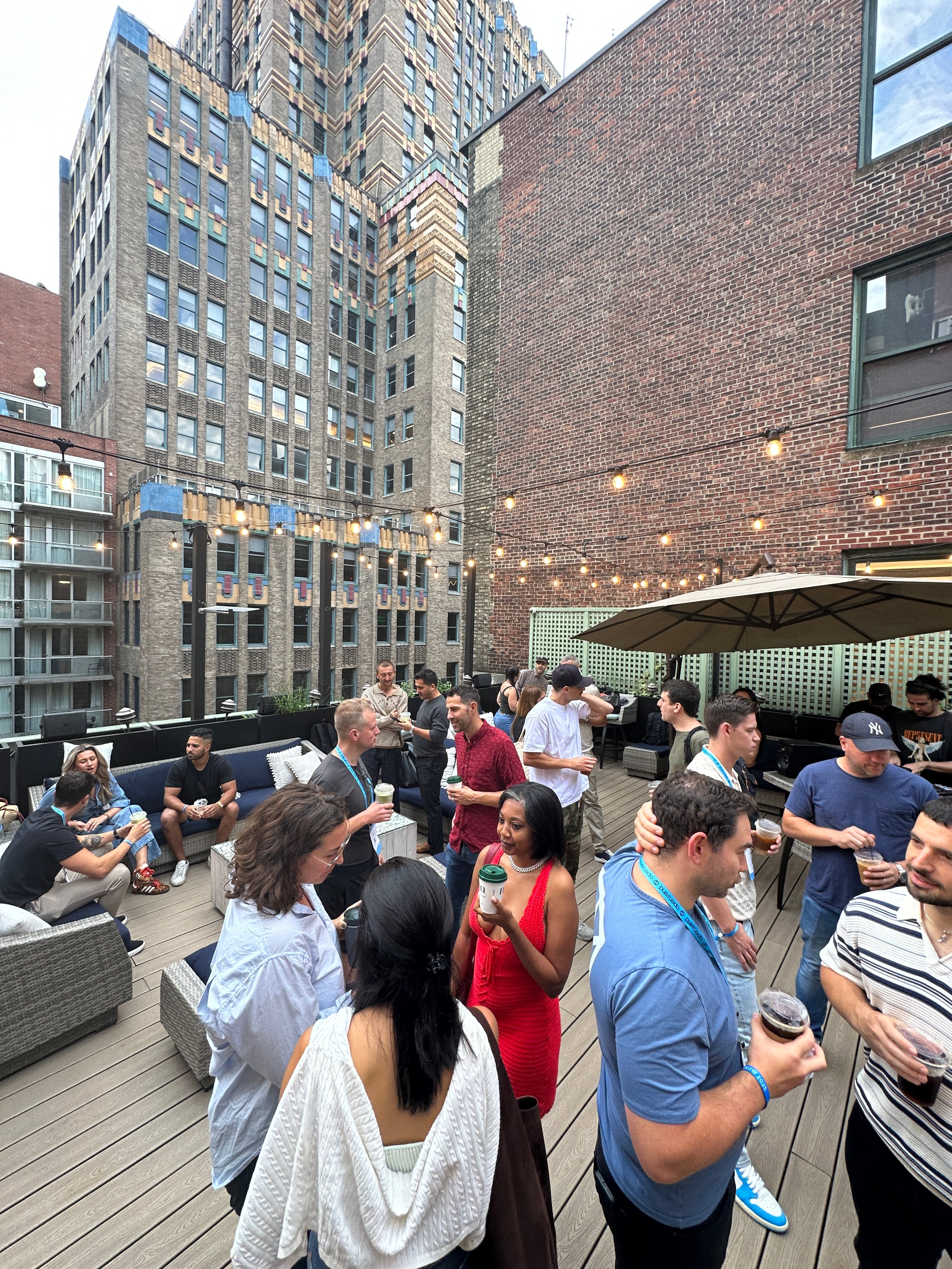 Rooftop networking event with string lights and city skyline views