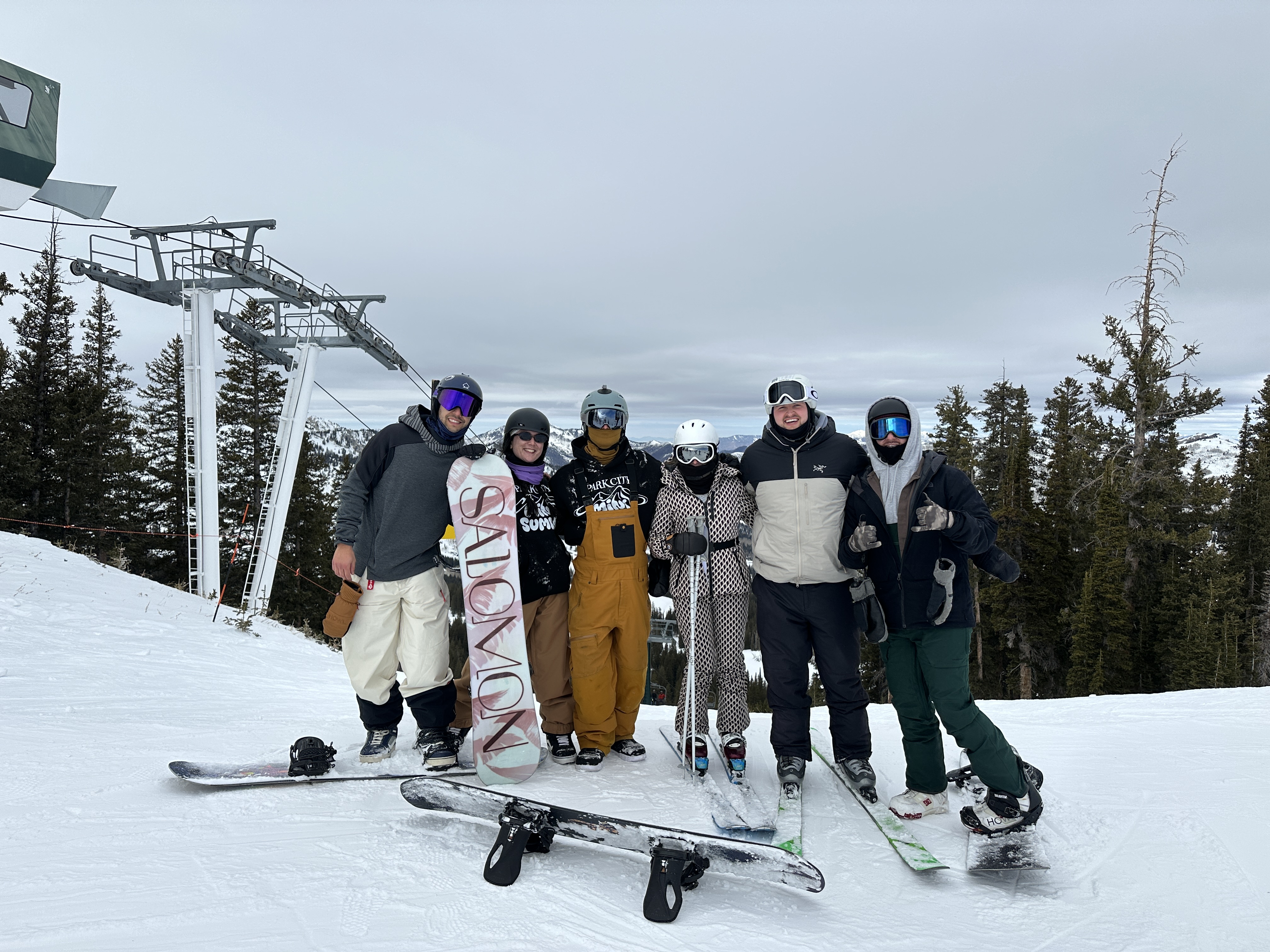Group of friends skiing and snowboarding at mountain resort near ski lift